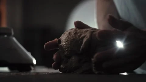 Baker hands kneading dough, performing pre-shaping stage, rounding portion of Stock Footage 342230394