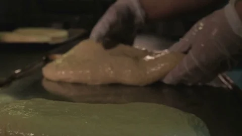 Baker hands kneading dough on table Stock Footage 84078036