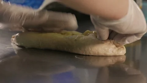 Baker hands kneading dough on table Stock Footage 84078306