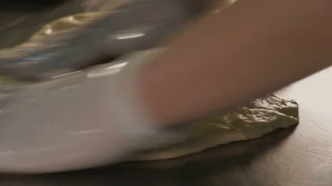 Baker hands kneading dough on table Stock Footage 84078923