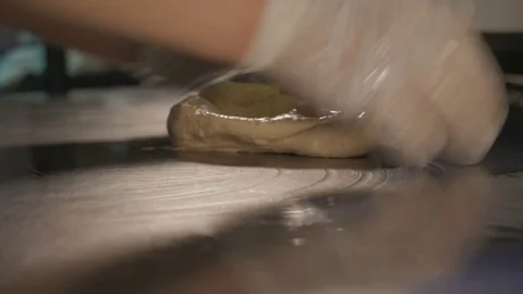 Baker hands kneading dough on table Stock Footage 84079089