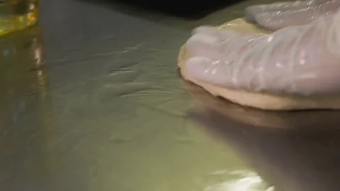 Baker hands kneading dough on table Stock Footage 84079472