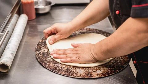 Baker hands making dough for pizza Stock Photos