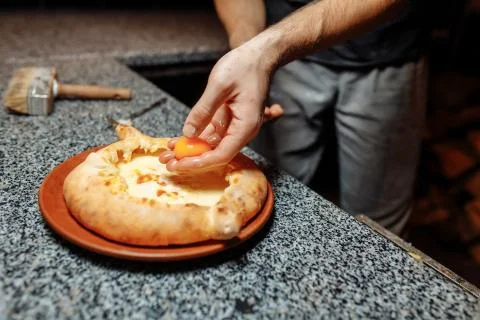 Baker hands preparing khachapuri on kitchen table. cook making traditional ge Stock Photos