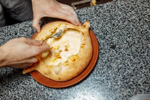 Baker hands preparing khachapuri on kitchen table. cook making traditional ge Stock Photos