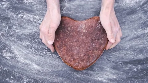 Baker hands puts vegan rye yeast-free sourdough artisan bread shape heart Stockbeeldmateriaal 130495277