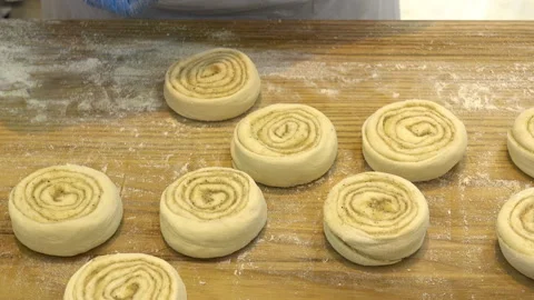 Baker hands shape buns for baking on wooden table Stock Footage 112930805