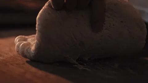 Baker hands shaping dough on wooden surface for artisanal bread and rolls in Stock Footage 344844506