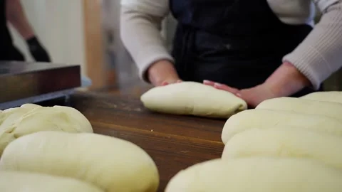 Baker hands skillfully kneading and forming bread loaves Stock Footage 313531697