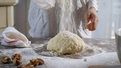 Baker hands throwing flour kneading dough in flour on table. Stock Footage 96393883