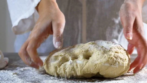 Baker hands throwing flour kneading dough in flour on table. Slow Motion. Stock Footage 96395912