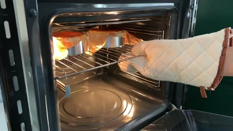 Baker hands wearing gloves taking a cake out of the oven. Stock Footage 130850353