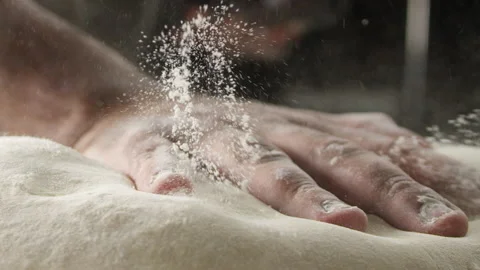 Baker hitting dough with flour on counter Stock Footage 274688897