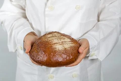 Baker holding fresh bread in the hands of Stock-Fotos