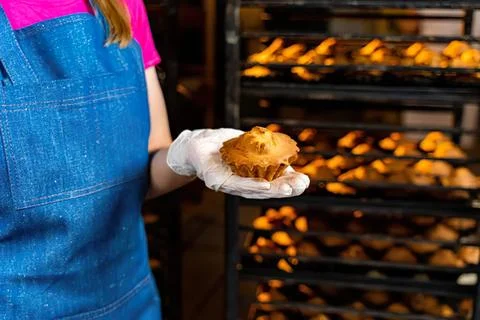 Baker holding freshly baked bread in bakery shop Stock Photos