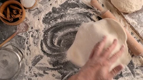 Baker holds dough circle over the cutting table. Stock Footage 130531462