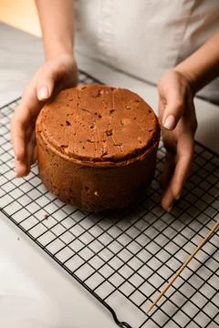 Baker holds the Easter cake in his hands, which is lying on the rack Foto stock