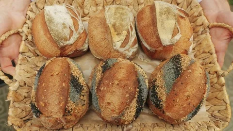 The baker holds in hands a of fresh bread close-up. Artisan bread is making by Stock Footage 266830909