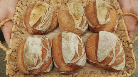 The baker holds in hands a of fresh bread close-up. Artisan bread is making by Stock Footage 270020252