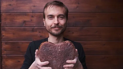 Baker holds, sniffs and enjoys aroma vegan rye whole grain sourdough bread Video stock 130495376