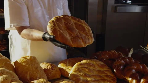Baker holds a traditional bread without yeast. Healthy, natural bread, made Stock Footage 277866093