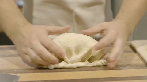Baker kneading and shaping bread dough into a ball Video stock 87612236