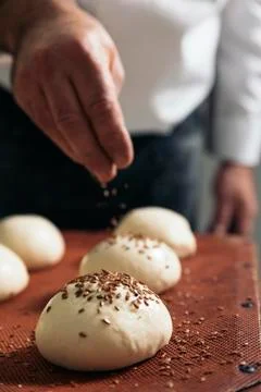 Baker kneading dough in a bakery. Stock Photos