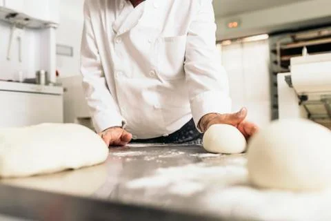 Baker kneading dough in a bakery. Foto stock
