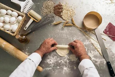 Baker kneading dough in a bakery. Stock Photos