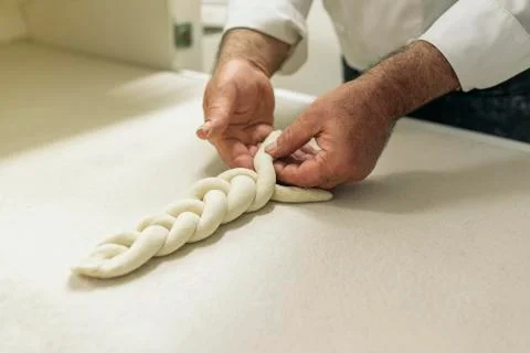 Baker kneading dough in a bakery. Stock Photos