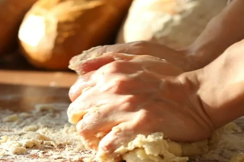 Baker kneading dough in flour on table Stock Footage 10735240
