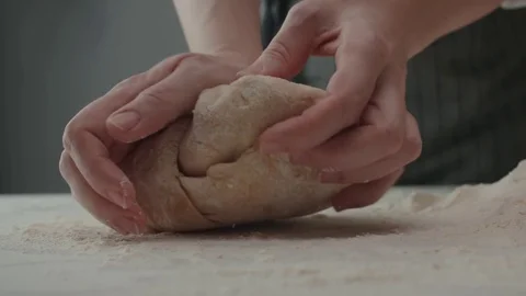 Baker kneading dough in flour on table, slow motion Stock Footage 70382273