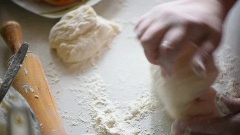 Baker kneading dough in flour on table Stock Footage 93800965