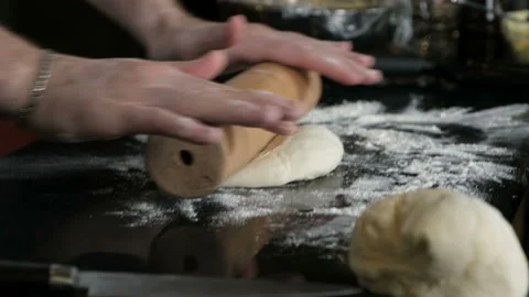 Baker kneading dough in flour on table Stock Footage 96381775