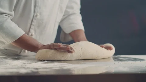 Baker kneading dough in flour on table. Slow motion video 4K Stock Footage 105100068