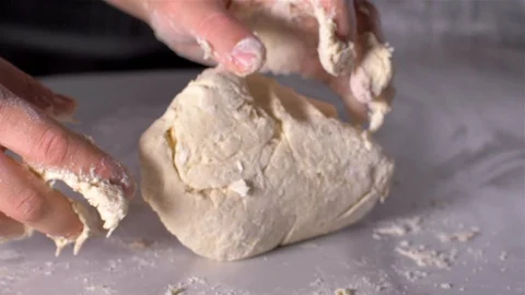 Baker kneading dough in flour on table, slow motion 스톡 동영상 106153011