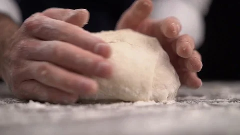Baker kneading dough in flour on table Video stock 123916425