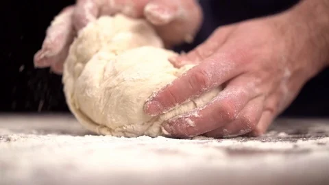 Baker kneading dough in flour on table Stock Footage 123916430