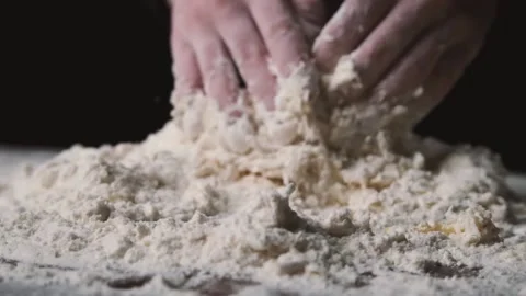 Baker kneading dough in flour on table. Process of mixing flour with egg and Stock-Footage 131238084
