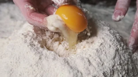 Baker kneading dough in flour on table. Process of mixing flour with egg and Stock-Footage 131238471