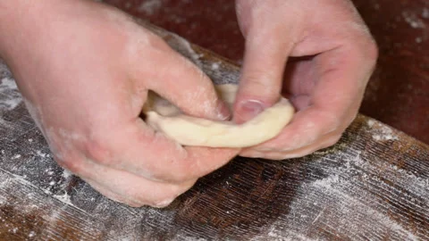 Baker kneading dough in flour on table. Stock Footage 249885076