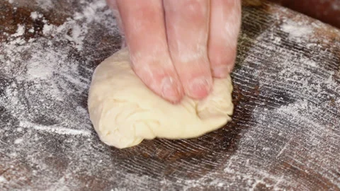Baker kneading dough in flour on table. Vídeos de archivo 249885144