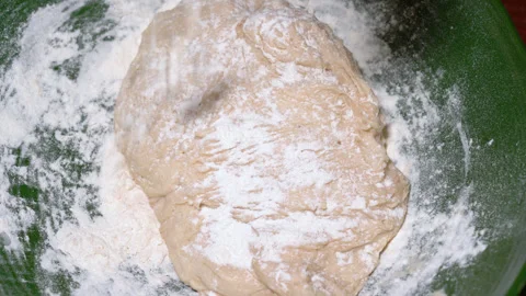 Baker kneading dough in flour on table. Stock Footage 252460387