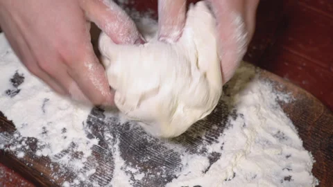 Baker kneading dough in flour on table. Stock Footage 254168388