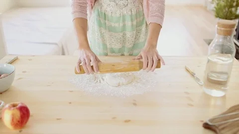 Baker kneading dough with rolling pin on wood table at home Stock Footage 70941527