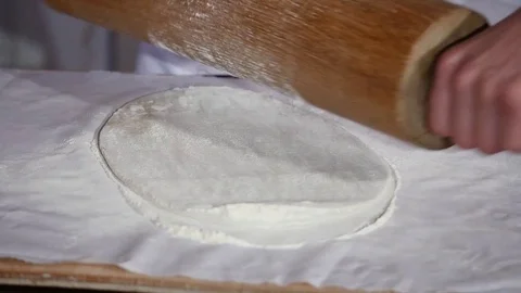 Baker kneading dough with rolling pin on table Stock Footage 77567171