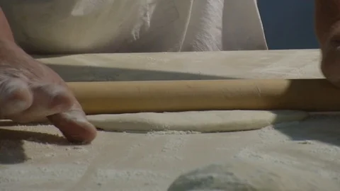 Baker kneading dough with rolling pin on table. Woman rolling dough for pizza. Stock Footage 90721753