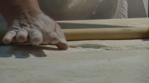 Baker kneading dough with rolling pin on table. Woman rolling dough for pizza. Stock Footage 90722468