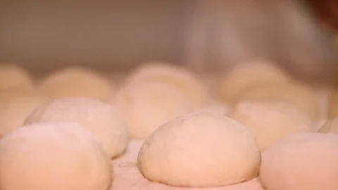 Baker kneading dough with rolling pin on table. Woman rolling dough for pizza. R Stock Footage 90731252