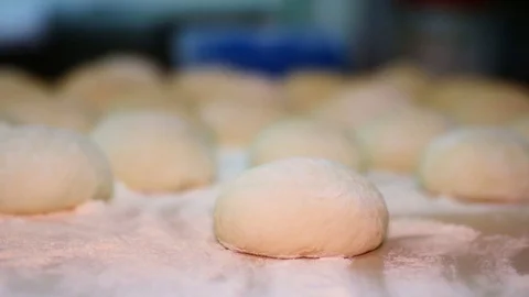 Baker kneading dough with rolling pin on table. Woman rolling dough for pizza. R Stock Footage 90731540